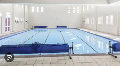 a large swimming pool in a large room at Italian luxe 6 sleeper apartment near canal walk in Cape Town