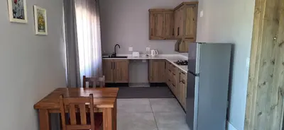 a kitchen with a wooden table and a refrigerator at Family Cottage no 4 in Wellington