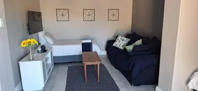a small room with a bed and a couch at Family Cottage no 4 in Wellington
