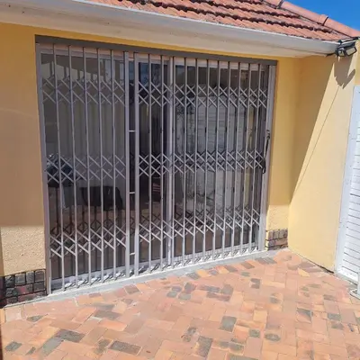 an iron gate on the side of a building at Peaceful one bedroom guesthouse in Rondebosch in Cape Town