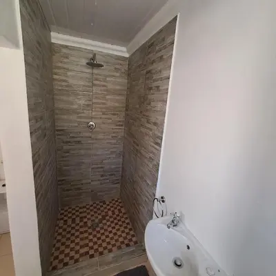a bathroom with a shower with a toilet and a sink at Peaceful one bedroom guesthouse in Rondebosch in Cape Town