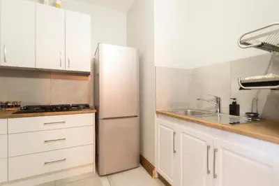 a kitchen with white cabinets and a stainless steel refrigerator at Mountain and Tides in Kleinmond