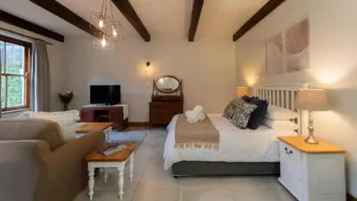 a bedroom with a bed and a living room at Mountain and Tides in Kleinmond