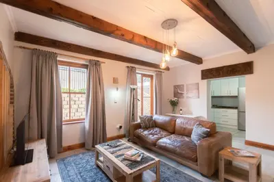 a living room with a leather couch and a table at Mountain and Tides in Kleinmond