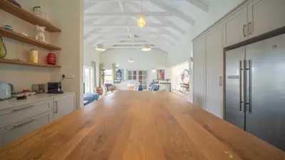 a kitchen with a large wooden table in a room at Swallows Rest - Benguela Cove in Hermanus