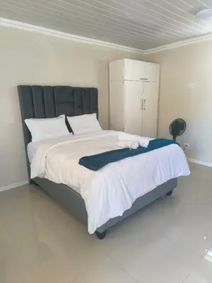 a bedroom with a large bed with a black headboard at On 10 breezand road in Cape Town