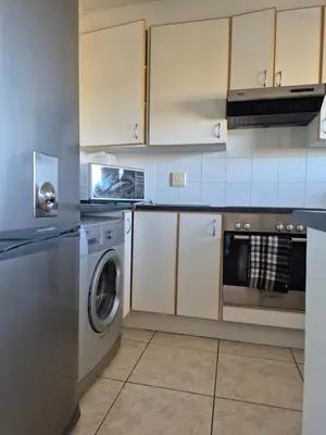 a kitchen with a washing machine and a washer at Apartment in Milnerton, Royal Ascot, Cape Town in Cape Town
