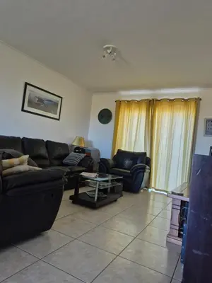 a living room with a couch and a table at Apartment in Milnerton, Royal Ascot, Cape Town in Cape Town