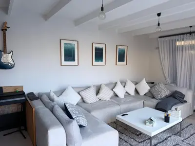 a white living room with a couch and a table at Modern & Secure 3-Bed Home with Pool & Garden in Cape Town