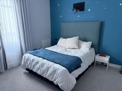 a blue bedroom with a bed with a blue wall at Modern & Secure 3-Bed Home with Pool & Garden in Cape Town