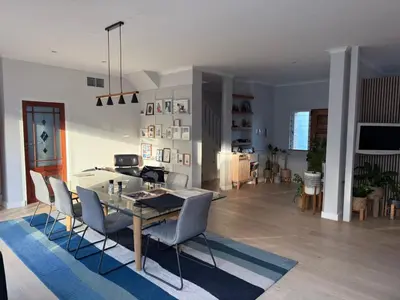 a dining room and living room with a table and chairs at Modern & Secure 3-Bed Home with Pool & Garden in Cape Town
