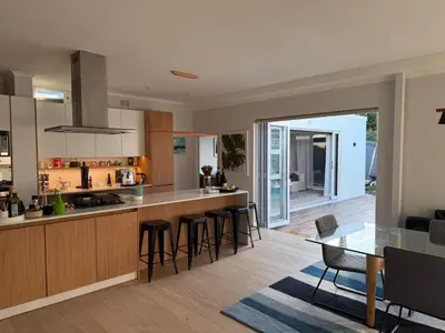 a kitchen and dining room with a table and chairs at Modern & Secure 3-Bed Home with Pool & Garden in Cape Town