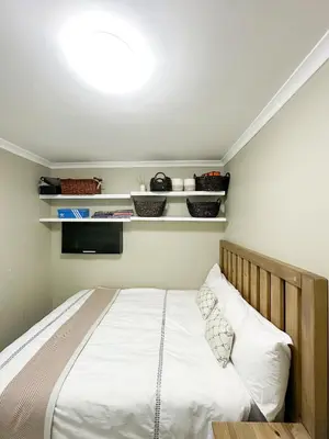 a bedroom with a bed with white sheets at 29 on Windsor Rooms- in Camelot,Kuilsriver in Silver Sands