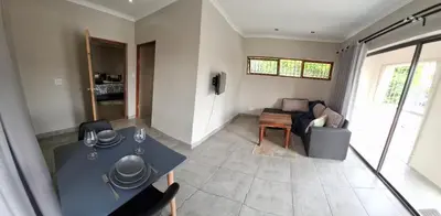 a living room with a table and a couch at Spacious Suite in Somerset West in Somerset West