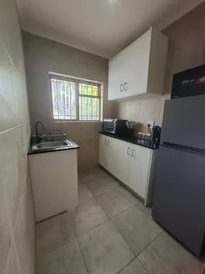 a kitchen with a sink and a refrigerator at Spacious Suite in Somerset West in Somerset West