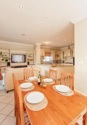 a dining room with a table and a kitchen at Charming Historic Home in Central Stellenbosch in Stellenbosch