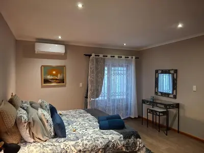 a bedroom with a bed and a window at Spacious Suite Somerset West in Somerset West