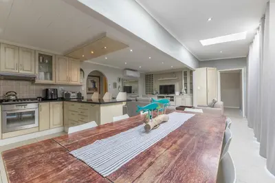 a kitchen with a large wooden table in a room at Fleurpark 6 in Gordonʼs Bay