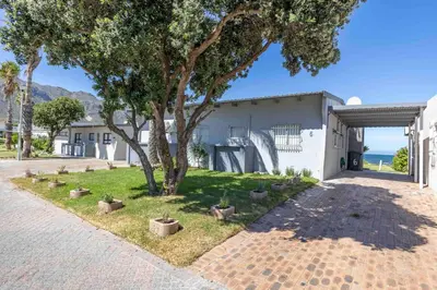 a house with a tree in the yard at Fleurpark 6 in Gordonʼs Bay