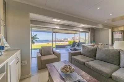 a living room with a couch and a table at Fleurpark 6 in Gordonʼs Bay