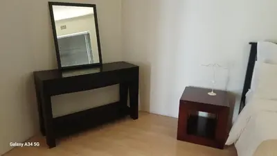 a bedroom with a mirror and a bed and a table at On The Bay in Strandfontein