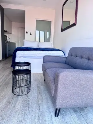 a living room with a bed and a couch at Modern Studio at 1 on Albert with Habour View in Cape Town
