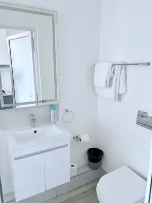 a white bathroom with a sink and a toilet at Harbour View Modern Studio at One on Albert in Cape Town