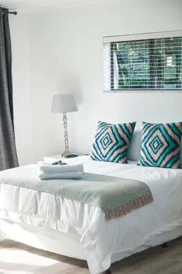 a bedroom with a white bed with a window at Crayfish at Hermanus Reefs in Hermanus