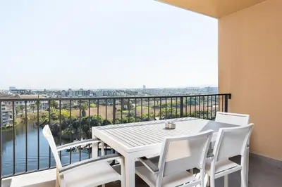 a white table and chairs on a balcony with a view at LuxeStay 2-Bed Century City Gem in Cape Town
