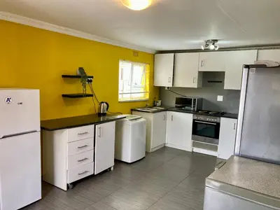 a kitchen with white appliances and a yellow wall at Unit 2 TraversHub Sleeps 6 Self-Catering Group Belhar, CT in Belhar
