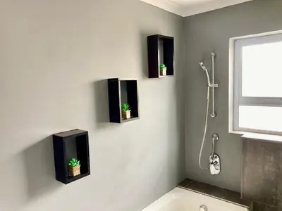 a bathroom with two plants on the wall at Unit 2 TraversHub Sleeps 6 Self-Catering Group Belhar, CT in Belhar