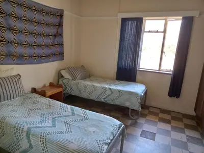 a room with two beds and a window at A Rustic and Reflective Nature Getaway in Greyton in Greyton