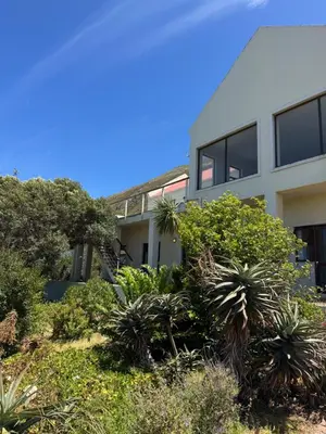 an apartment building with plants in front of it at Sea and Vlei on Disa in Bettyʼs Bay