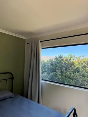 a bedroom with a large window and a bed at Sea and Vlei on Disa in Bettyʼs Bay