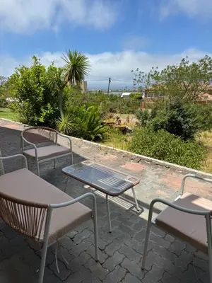 a group of chairs and tables on a patio at Sea and Vlei on Disa in Bettyʼs Bay
