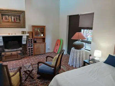 a bedroom with a bed and a living room at Chasselas Studio in Somerset West