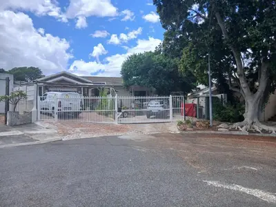 a white fence in front of a house at Chasselas Studio in Somerset West