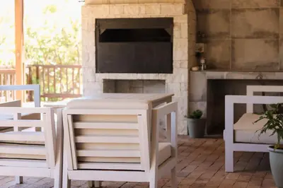 a white table and two chairs and a fireplace at Rissie's 3 Bedroom Apartment in Gordonʼs Bay