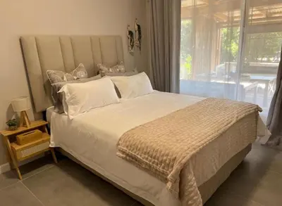 a bedroom with a large bed with a large window at Rissie's 3 Bedroom Apartment in Gordonʼs Bay
