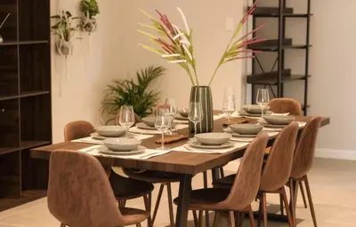 a dining room with a wooden table and chairs at Rissie's 3 Bedroom Apartment in Gordonʼs Bay