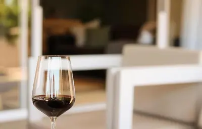 a glass of red wine sitting on a table at Rissie's 3 Bedroom Apartment in Gordonʼs Bay