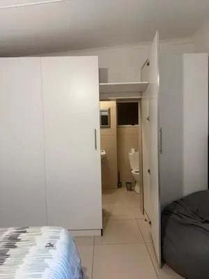 a bedroom with white walls and a bed and a bathroom at Sunny Snooze Holiday Home in Goodwood