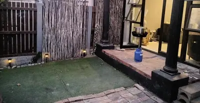 a yard with a blue bottle next to a building at Beach Vibes Villa in Cape Town