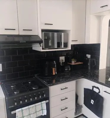 a kitchen with a stove and a microwave at Beach Vibes Villa in Cape Town