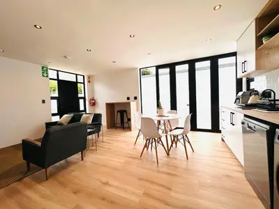 a kitchen and living room with a table and chairs at Modern Scandinavian Luxury Apartment in Hermanus