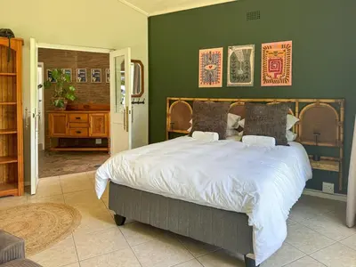 a bedroom with a large bed and a green wall at Spacious Holiday house with swimming pool in Blomtuin