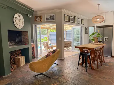 a living room with a table and a clock on the wall at Spacious Holiday house with swimming pool in Blomtuin