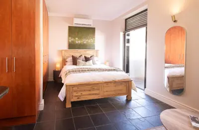 a bedroom with a bed and a mirror at 9 at Huis Piron - Location Stellies Central in Stellenbosch