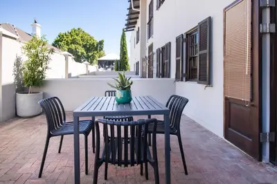 a black table and chairs on a patio at 9 at Huis Piron - Location Stellies Central in Stellenbosch