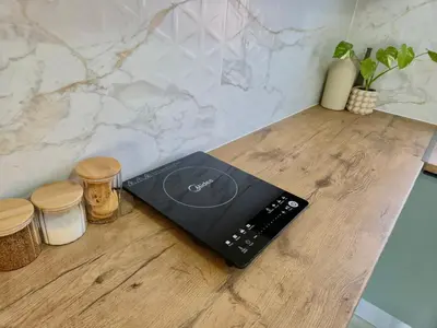 a laptop sitting on top of a wooden counter at Sand & Sea Studio Hermanus in Hermanus